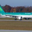 a green and white airplane on a runway