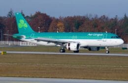 a green and white airplane on a runway