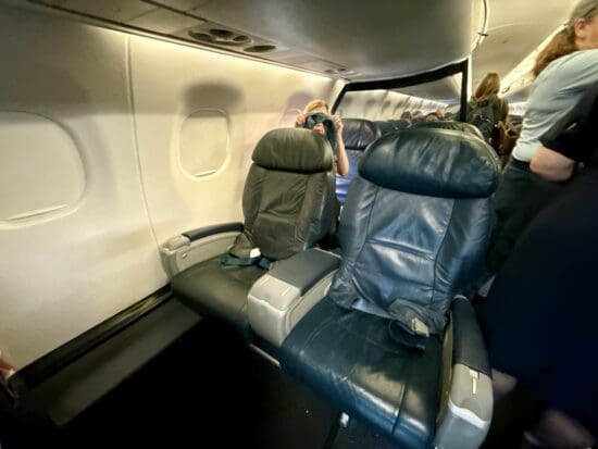 a group of people sitting in the United Embraer 170 First Class Cabin