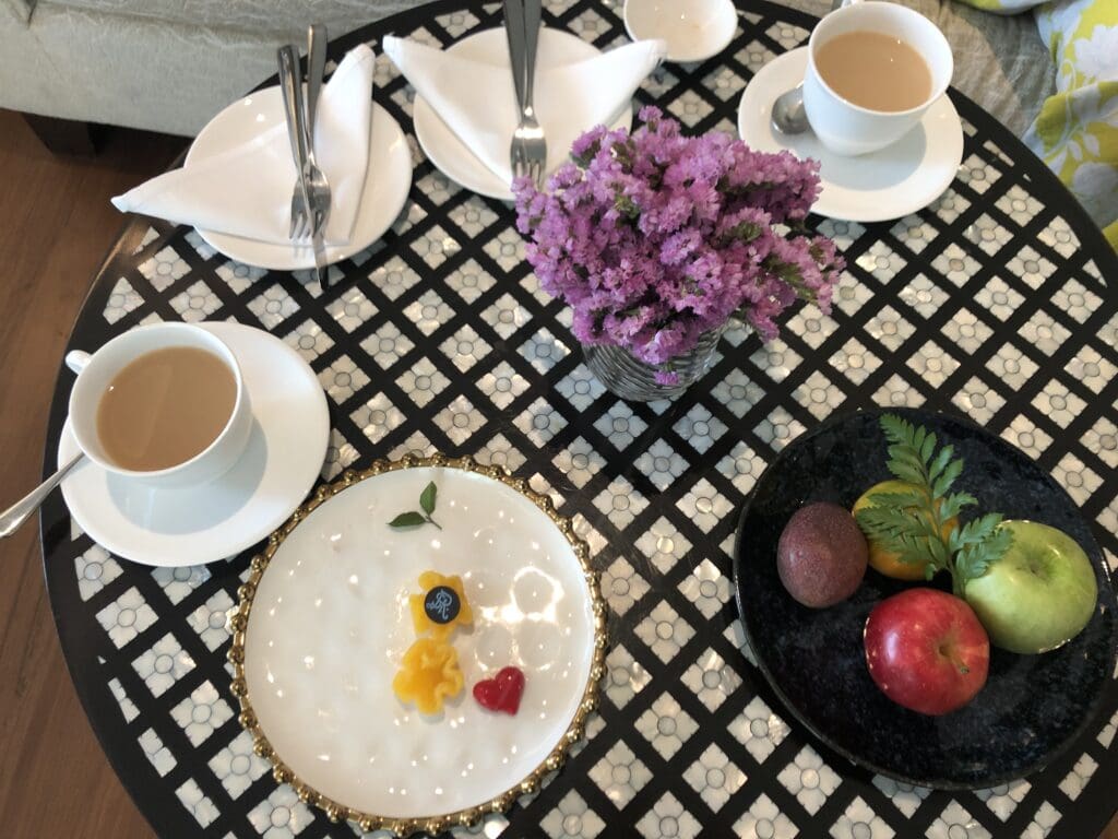 a table with plates and cups of coffee and fruit