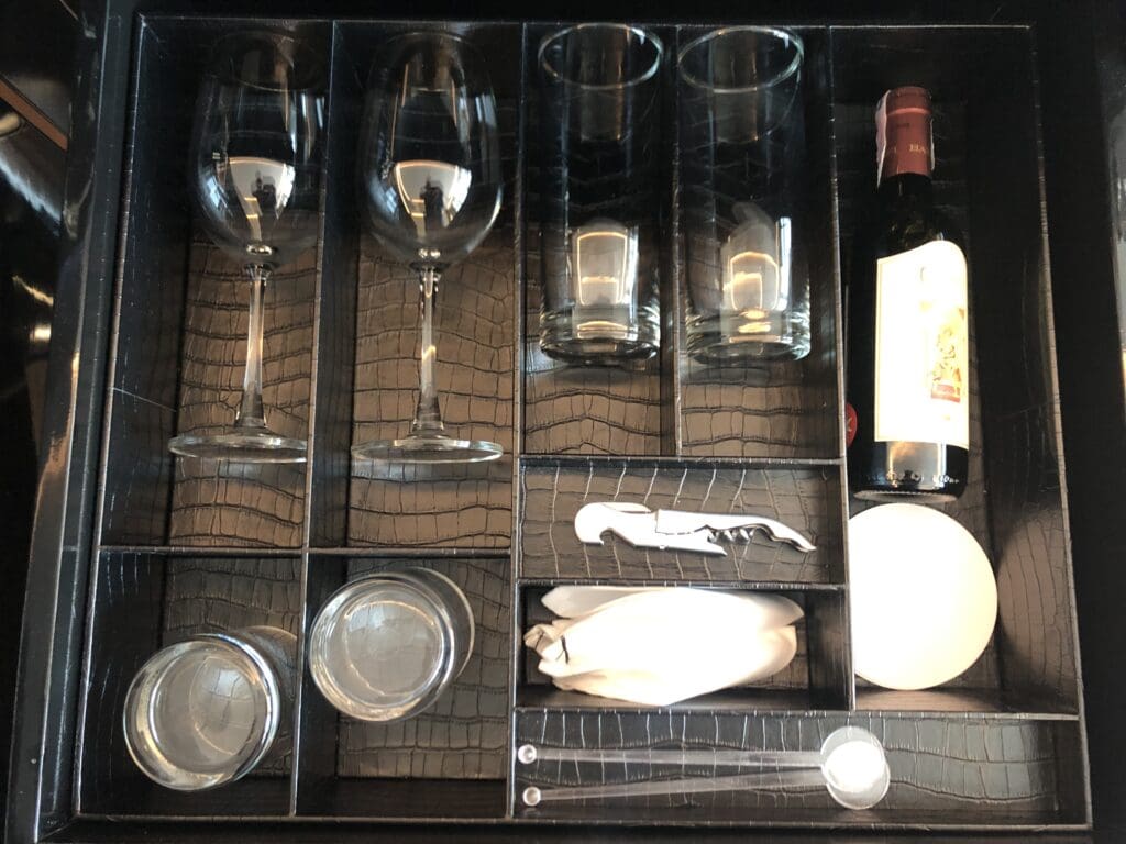 a wine bottle and glasses in a drawer