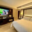 a room with a large television and a bed at the Peninsula Chicago