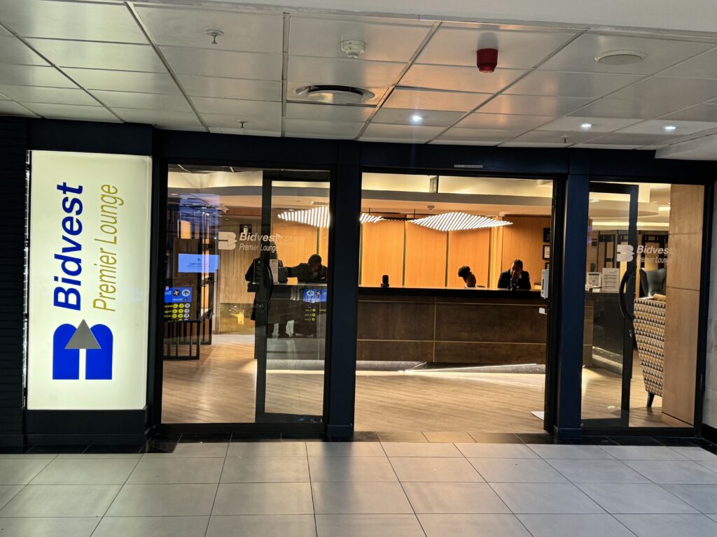 a lobby with glass doors and people standing in front of it