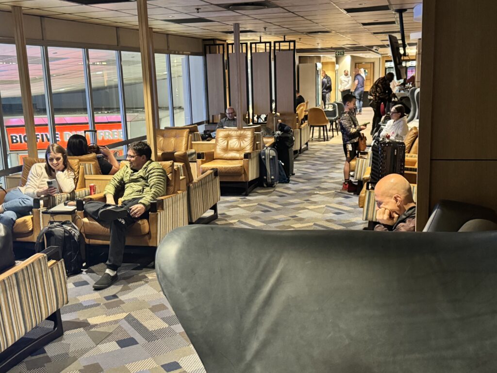 a group of people sitting in chairs in a room with windows