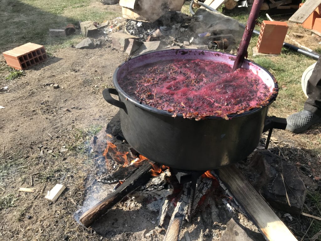 a large pot of red liquid on a fire