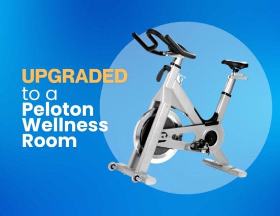 An image of a Peloton-like stationary bike on a gradient blue background accompanied by text to the left that reads "Upgraded to a Peloton Wellness Room"