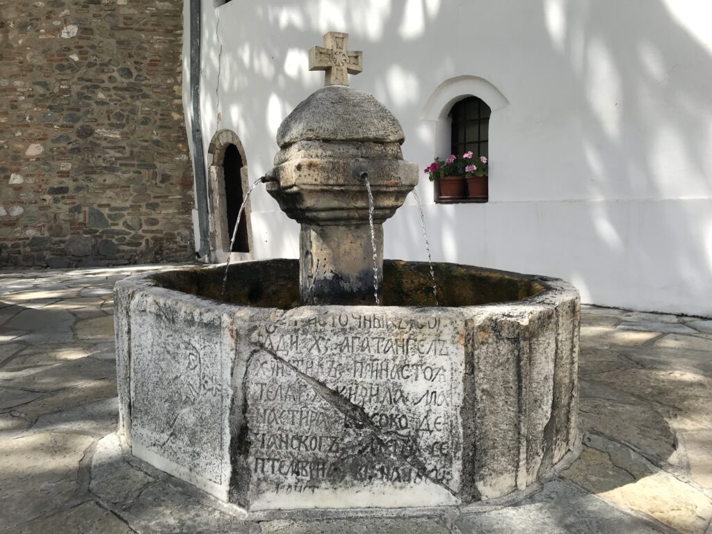 a stone fountain with a cross on top