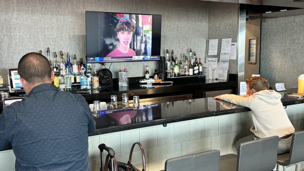 a bar with a television and bottles of alcohol