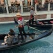 a group of people in gondolas in a canal