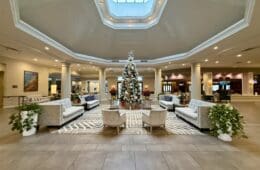 a large room with a christmas tree and chairs at the Hilton San Diego Del Mar