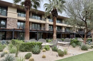 a building with palm trees and a patio