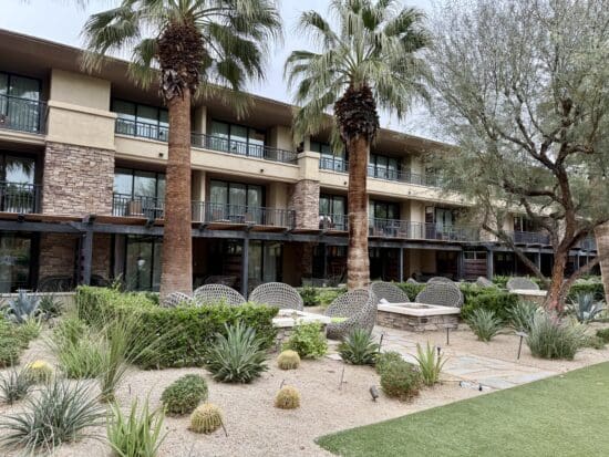 a building with palm trees and a patio