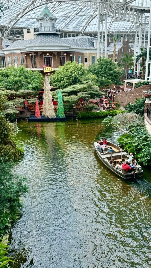 a boat on a river with trees and buildings