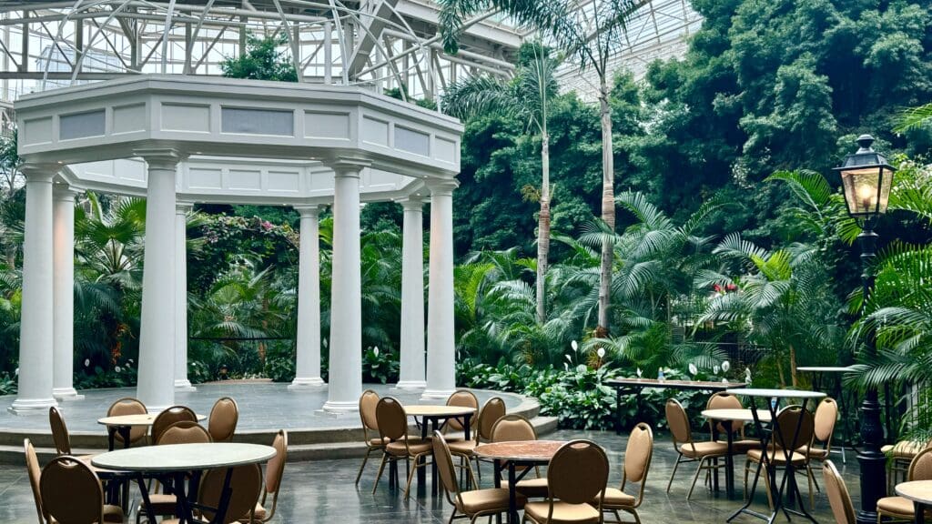 a room with tables and chairs in a tropical setting