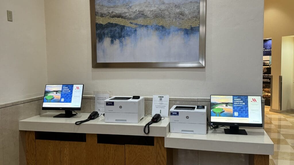 a desk with computers and boxes on it