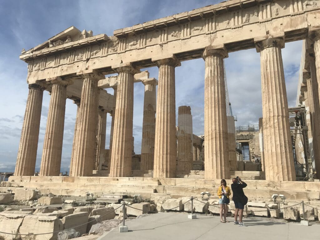 people a couple of people standing in front of Parthenon