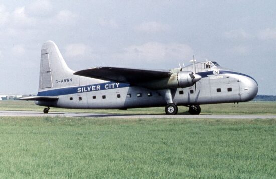 a silver airplane on a runway