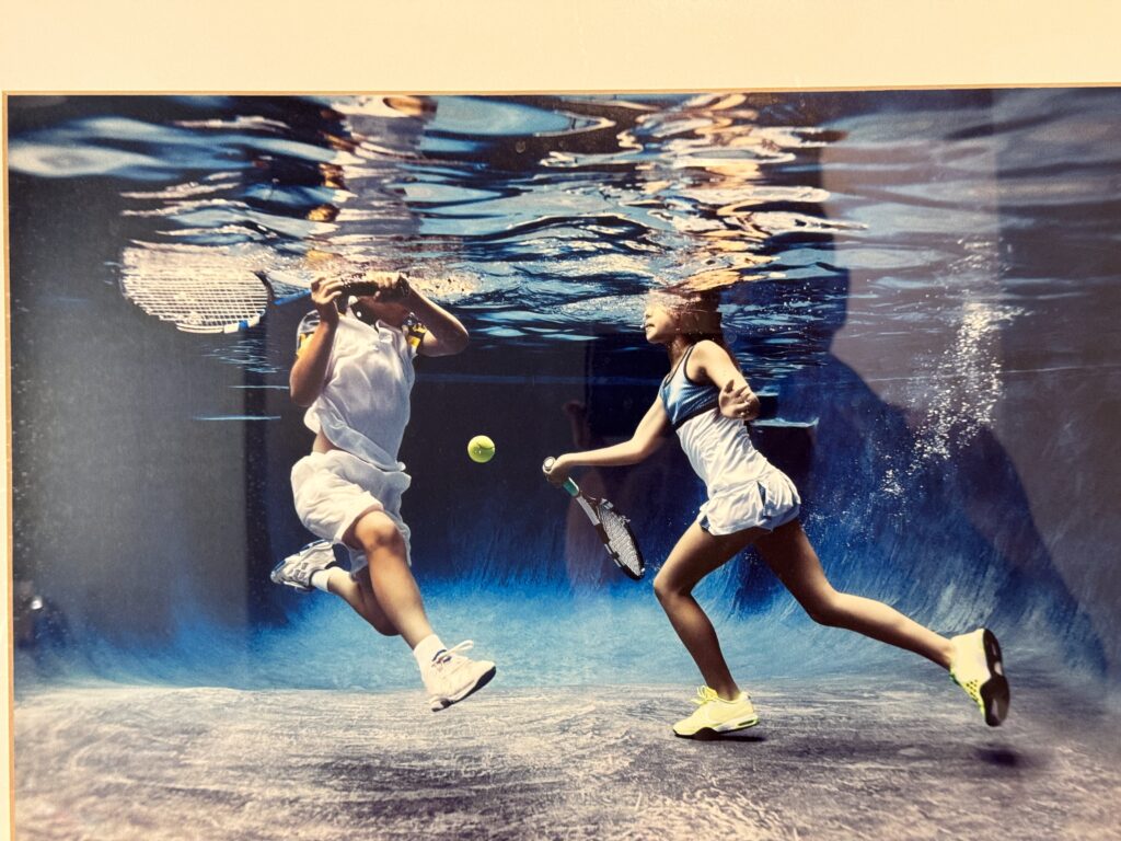 a couple of kids playing tennis underwater