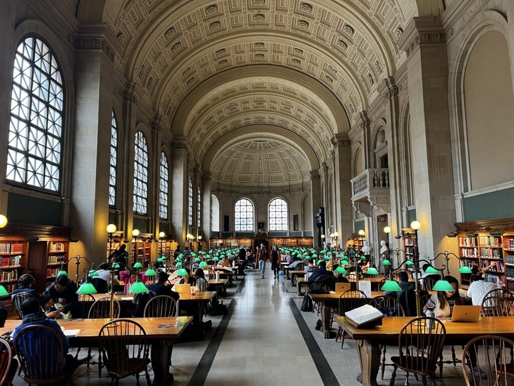 a group of people sitting at tables in a library