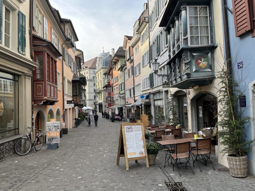 a street with tables and chairs in a city