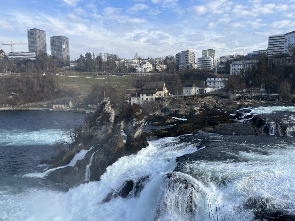 a waterfall with a city in the background