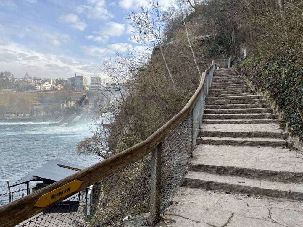 a stone stairs with a fence and a railing on a cliff