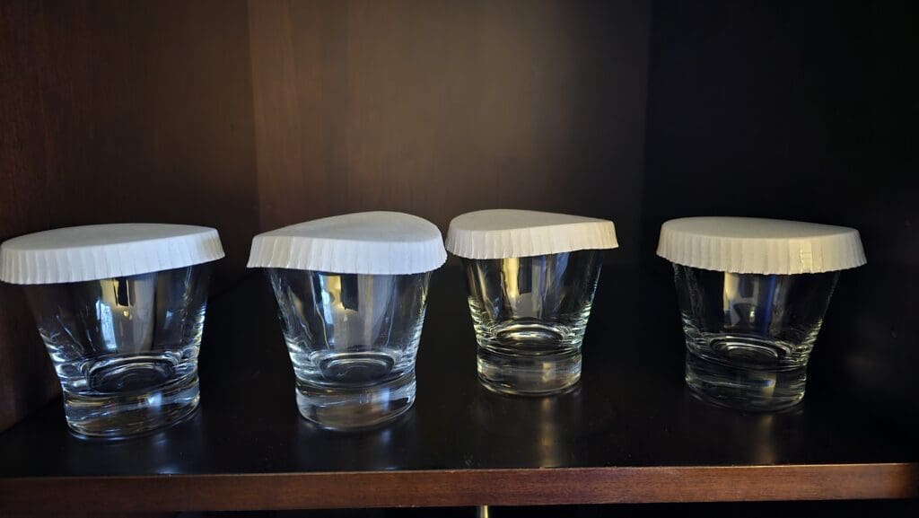 a group of empty glasses with a white lid on them