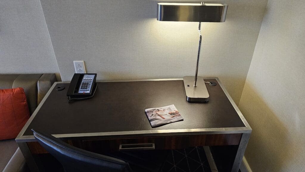 a desk with a lamp and telephone on it