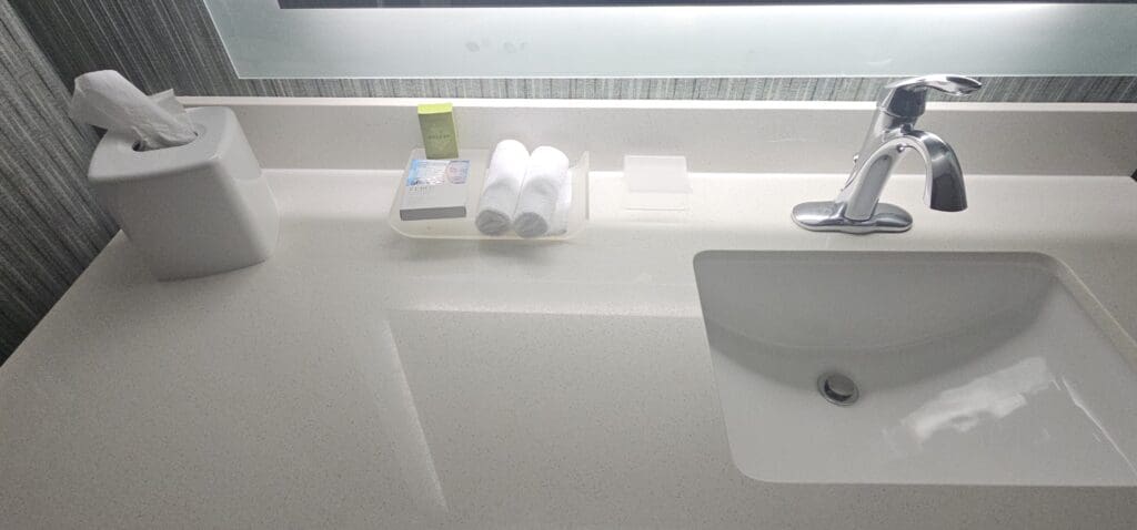 a sink and a soap dish with towels