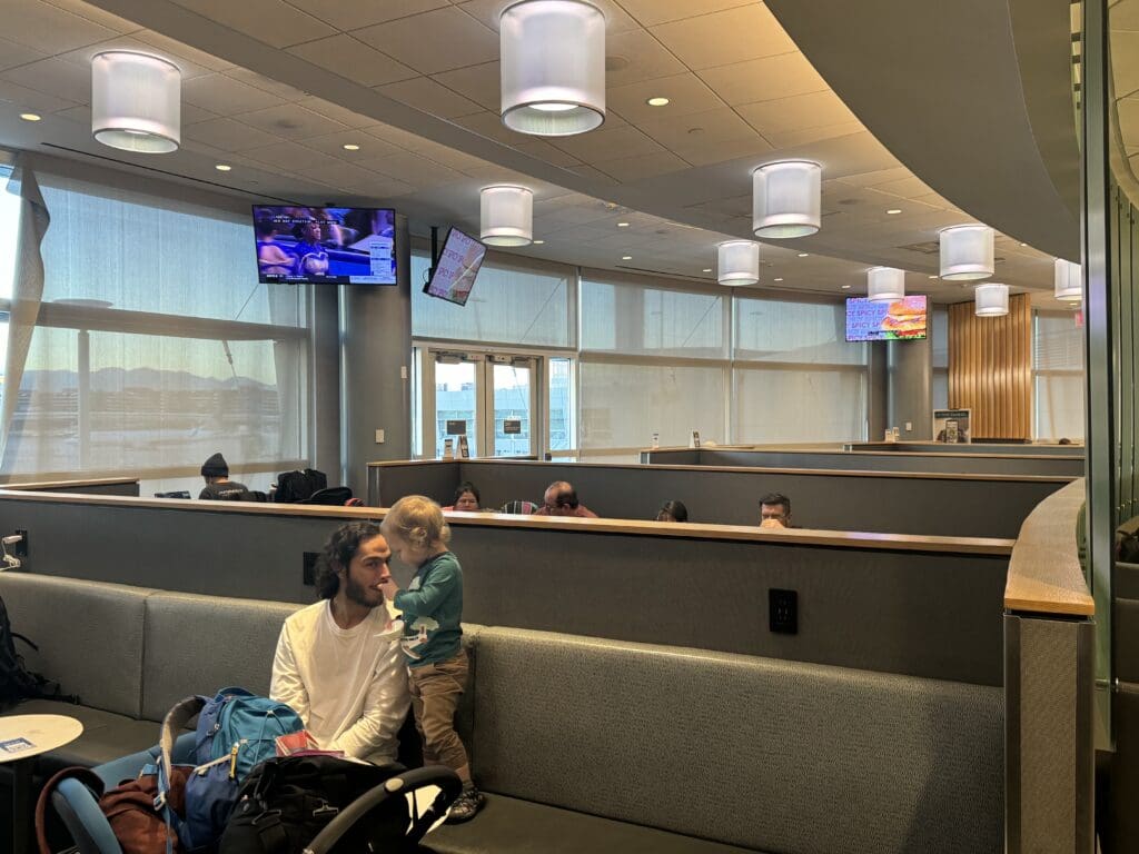 a man and child sitting on a bench in a waiting room