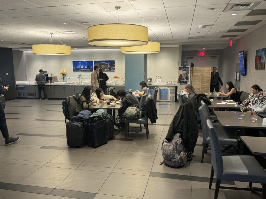 a group of people sitting at a table with luggage