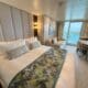 a bed in a room with a balcony and a table on the Sun Princess Deluxe Balcony