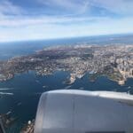 an airplane wing and view of a city and water