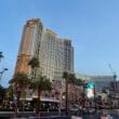 a large building with palm trees and a street