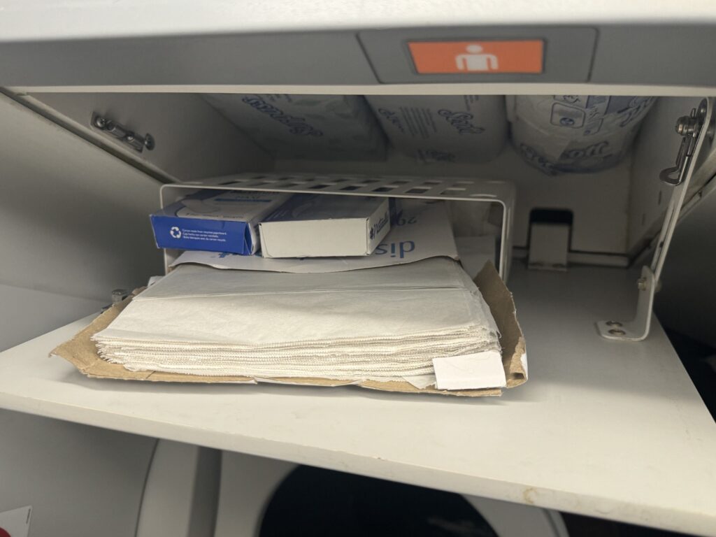 a shelf with a stack of tissues and boxes in it