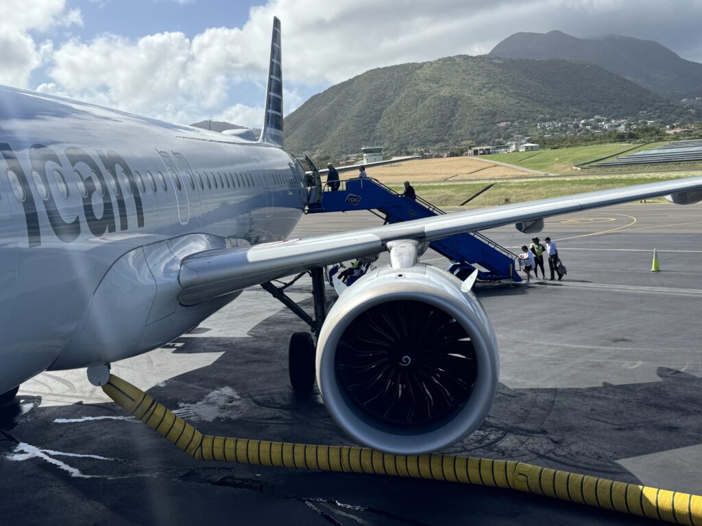 a jet plane with people boarding stairs