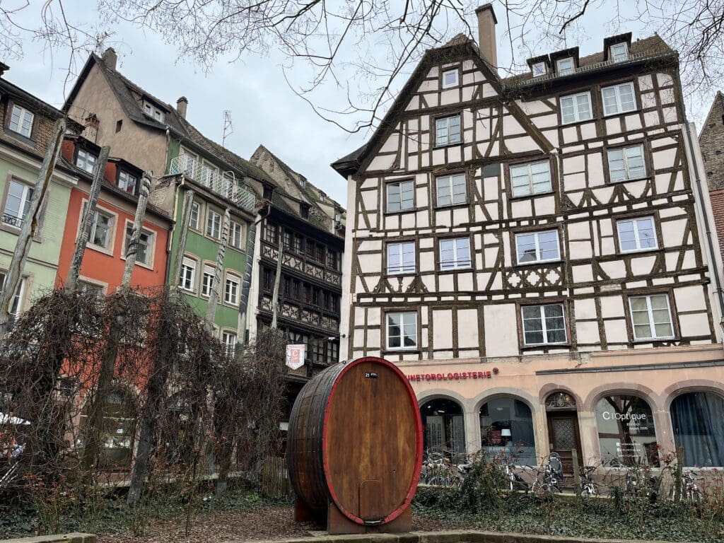 a wooden barrel in front of a building