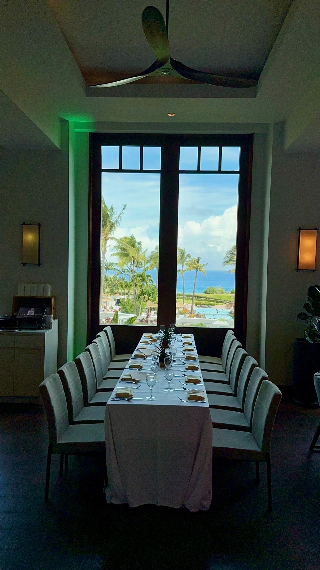 a table with chairs and a view of the ocean through a window