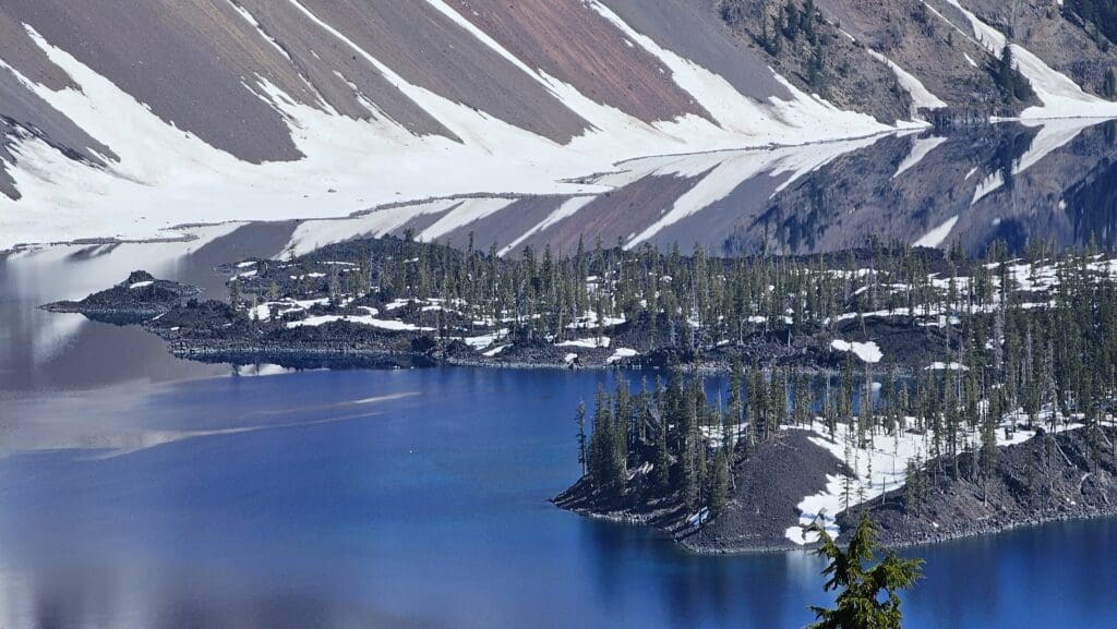 a body of water with snow and trees