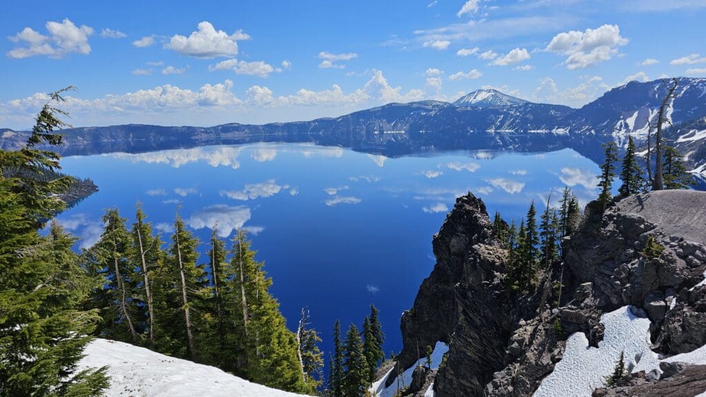 a body of water with trees and mountains in the background