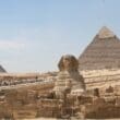 a group of people walking around a pyramid