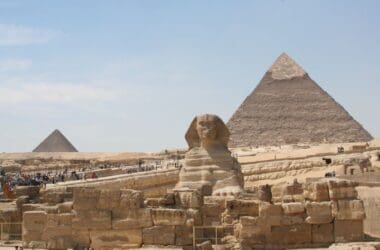 a group of people walking around a pyramid