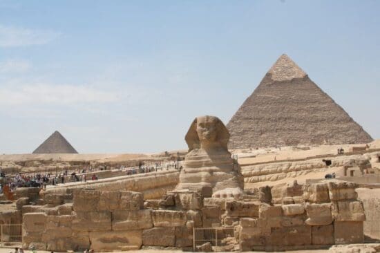 a group of people walking around a pyramid