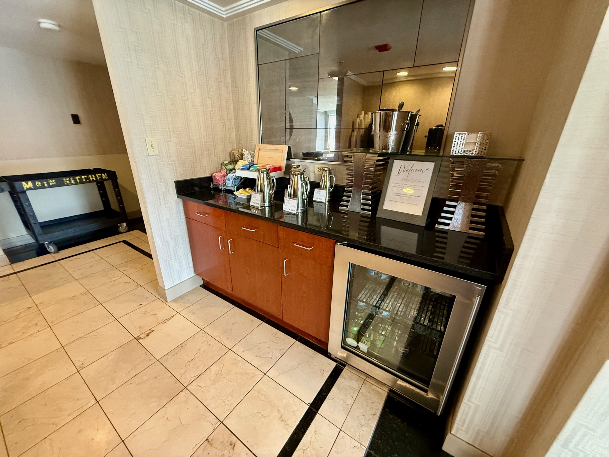 a counter with a refrigerator and a mirror above it