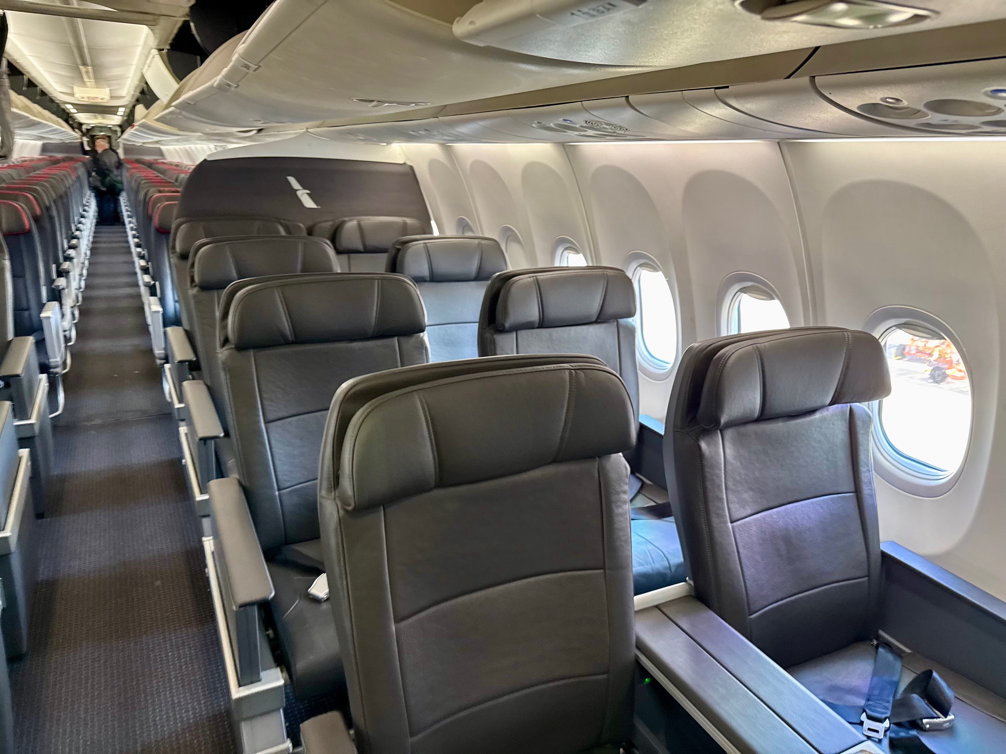 a row of seats in American Airlines A319 First Class