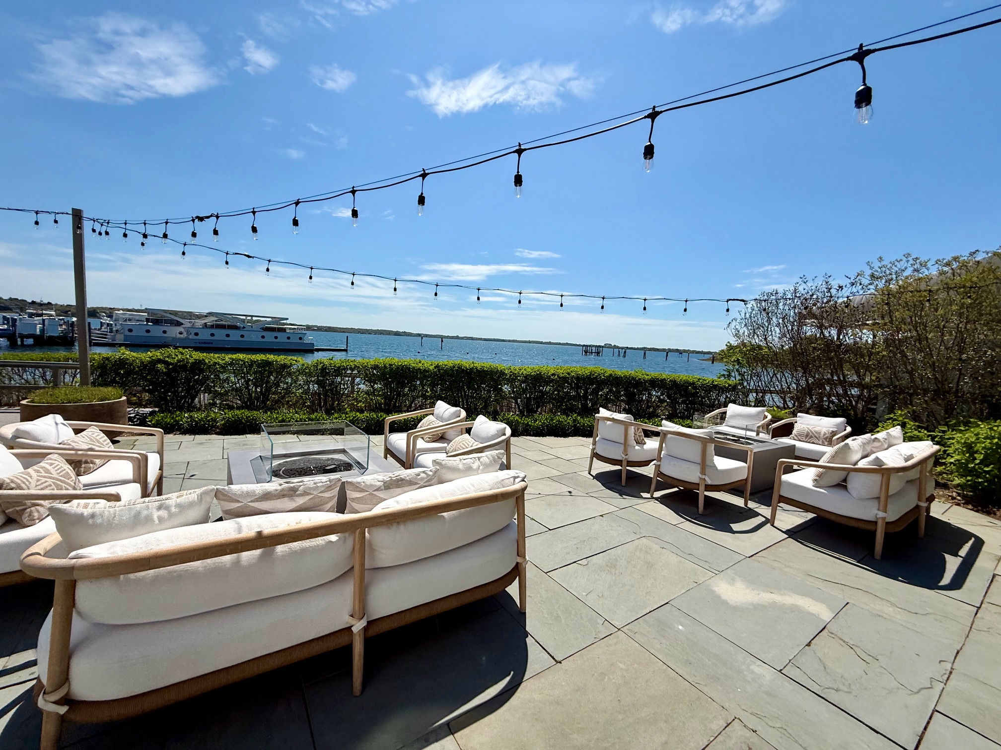 a patio with white furniture and a string of lights