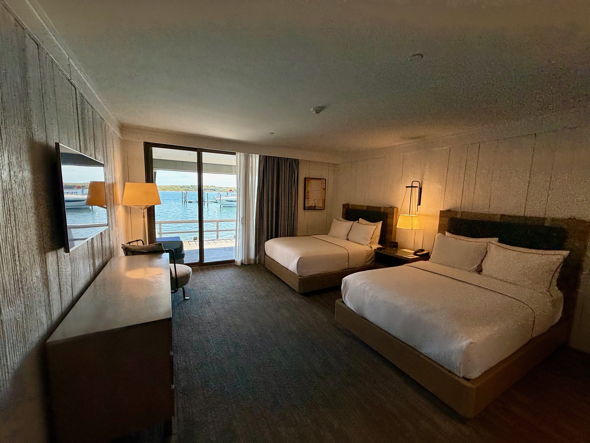 a room with two beds and a window with a view of the water at the Montauk Yacht Club