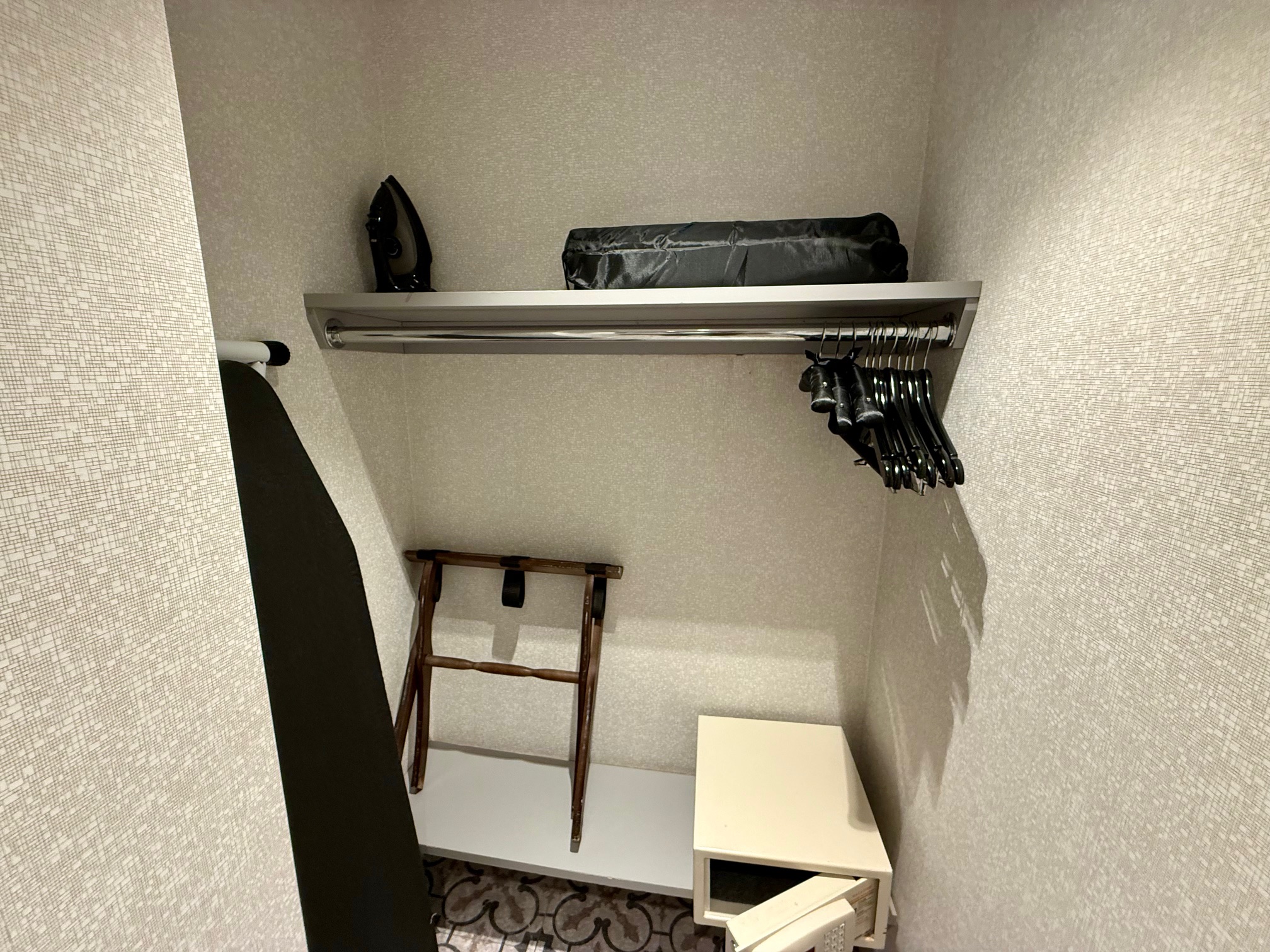 a closet with a shelf and swingers