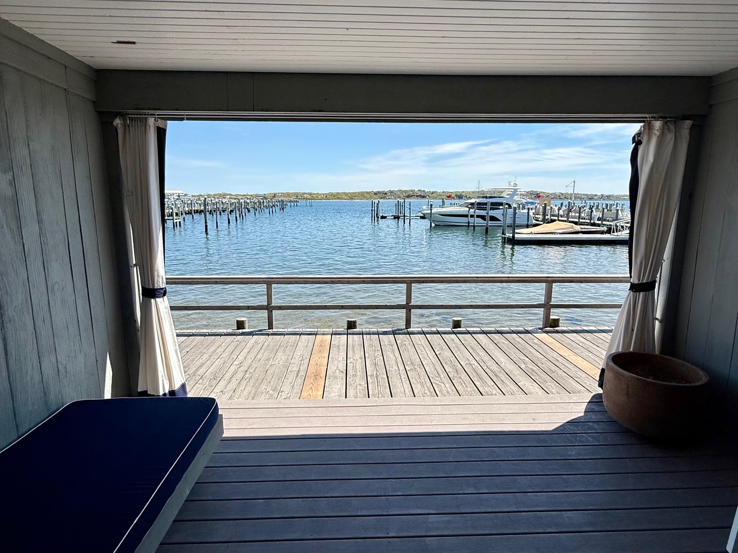 a view of a dock from a deck with a boat in the water from the room at the Montauk Yacht Club