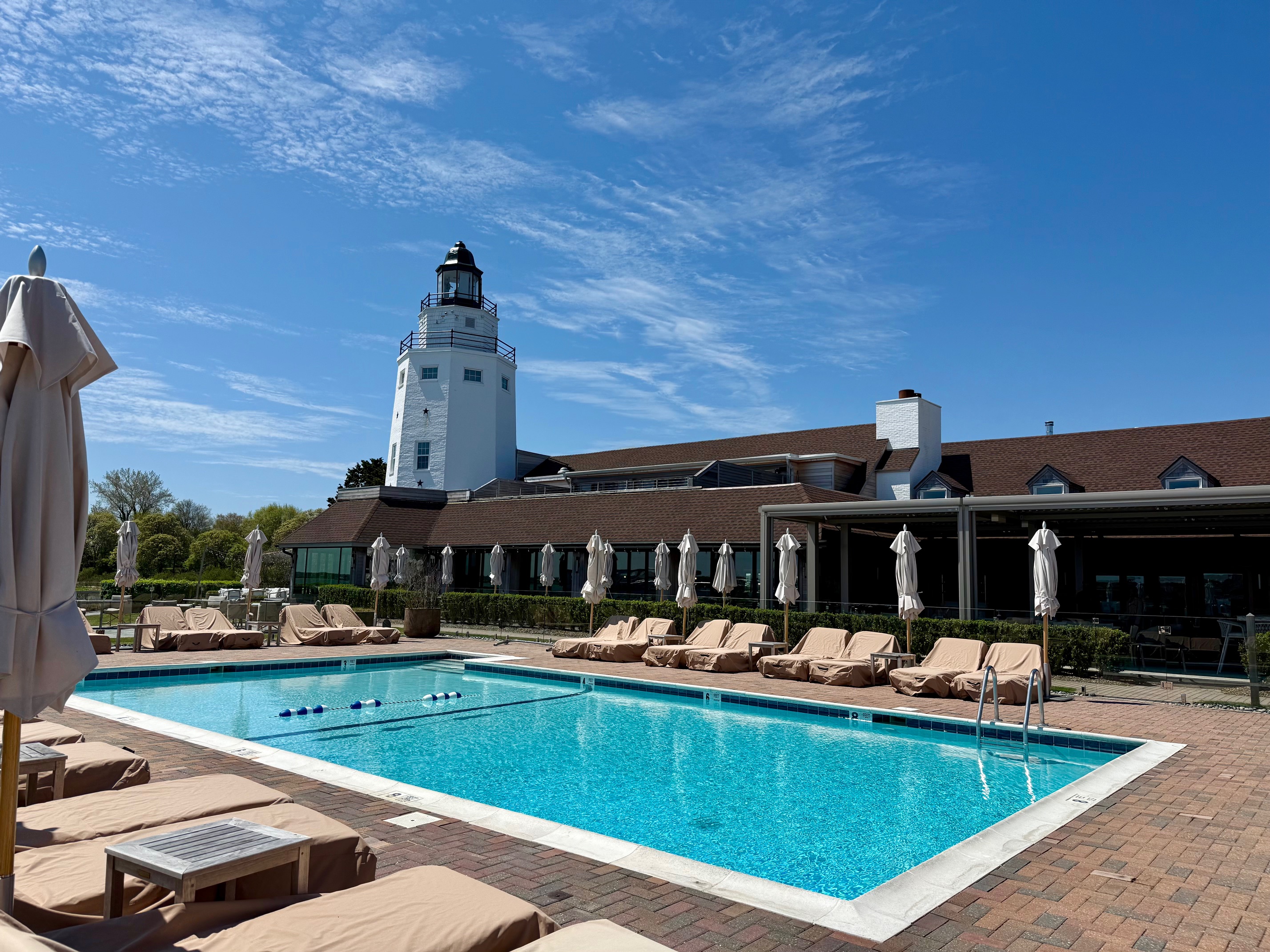a pool with lounge chairs and umbrellas at the Montauk Yacht Club